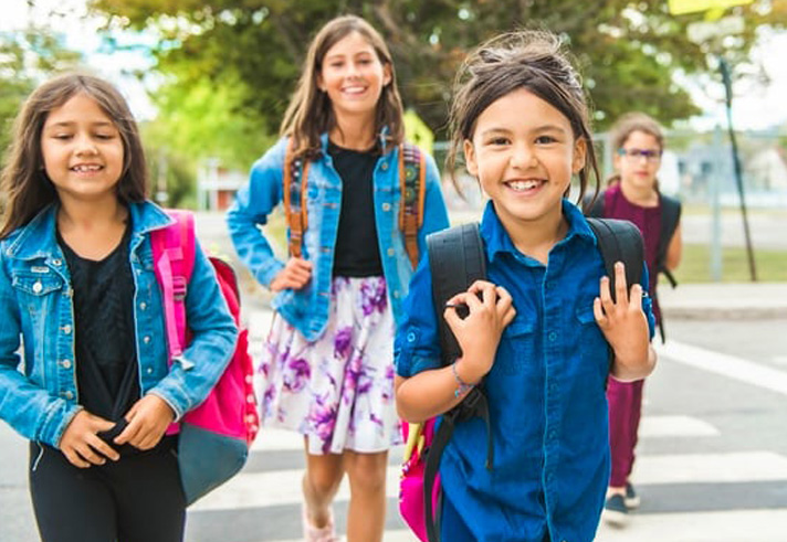 Image of Newcomer Children walking to school with backpacks